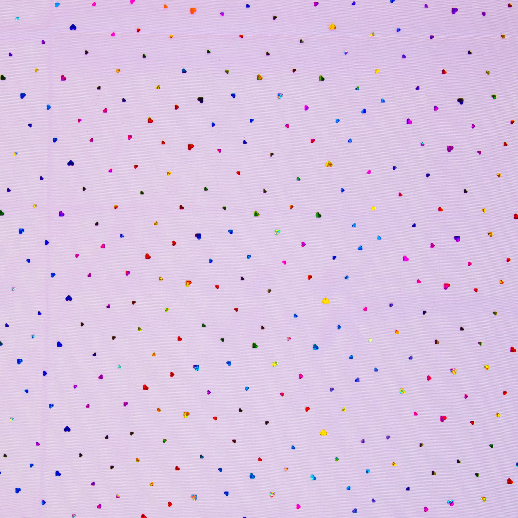Detailansich des flieder farbenen Tüll Stoffs mit glitzernden Herzen