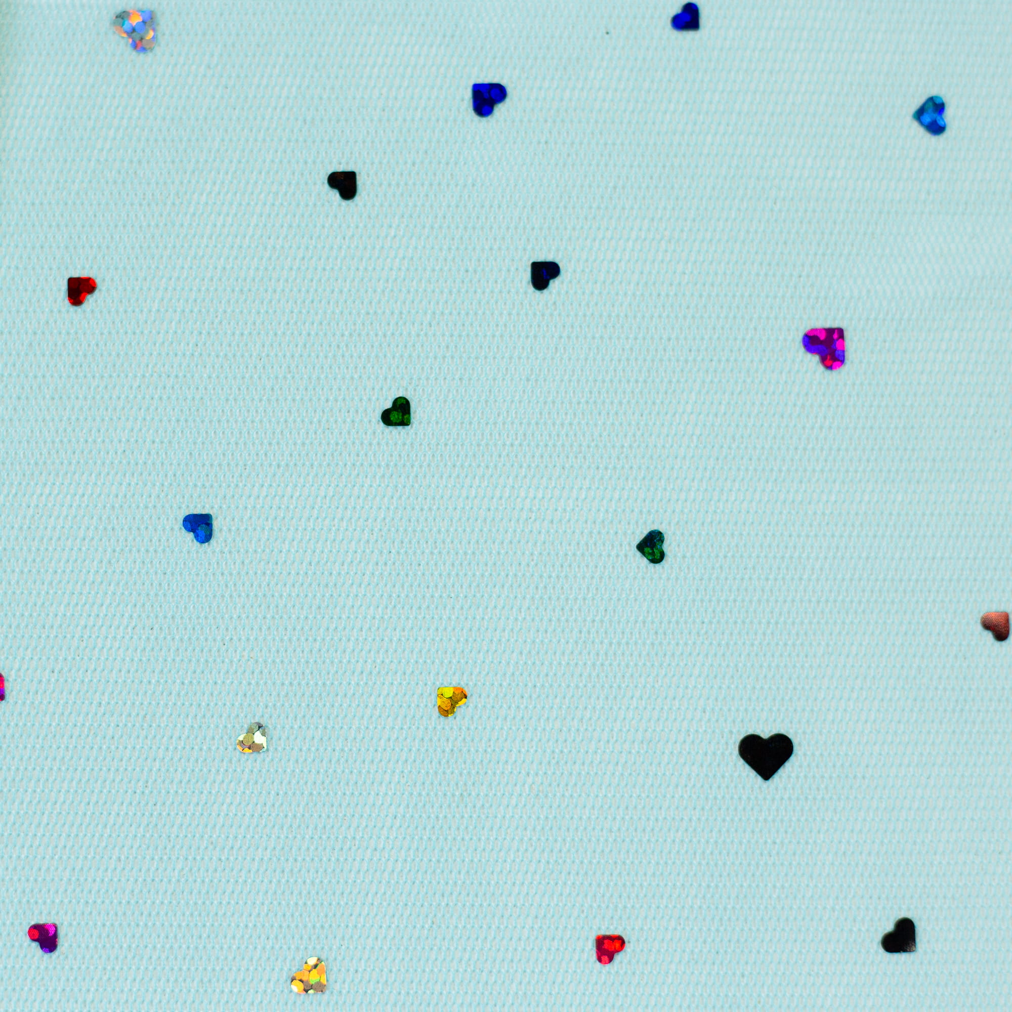 Detailansicht des aqua farbenden Tüll Stoffes mit glitzernden Herzen